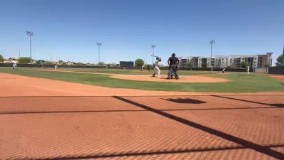 Baseball game in progress at the plate, viewed through the backstop